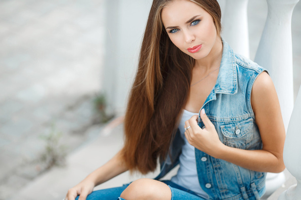 Portrait of young beautiful brunette in the city background - Foto, imagen