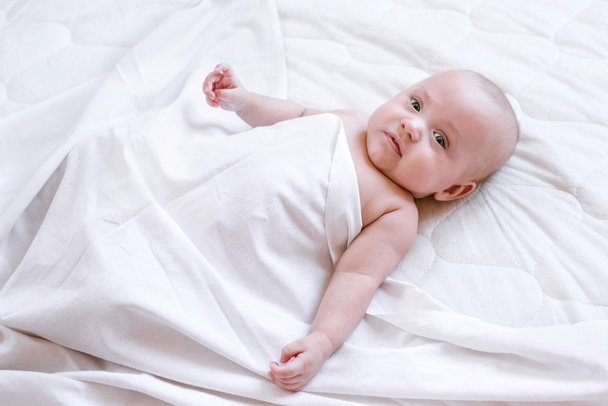 the newborn beautiful child lies on a white background - 写真・画像