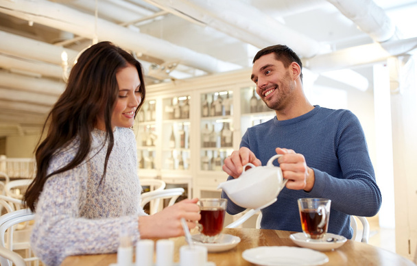 happy couple drinking tea at cafe - 写真・画像