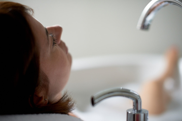Close up of a mature woman with her eyes closed in bathtub - Valokuva, kuva
