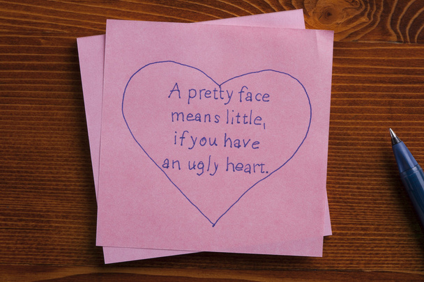 Sticky note with text A face means little,if you have an ugly heart - Valokuva, kuva