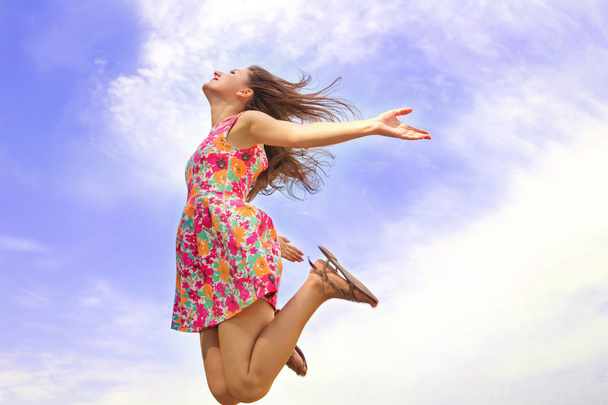 Menina feliz salta no céu
 - Foto, Imagem