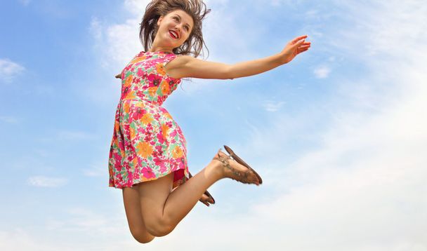 Menina feliz salta no céu
 - Foto, Imagem