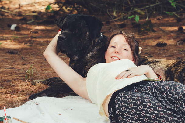 Girl on picnic lies on her big dog.  - Photo, image