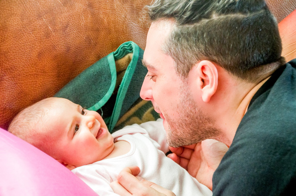 Тато робить обличчя морщачись новонародженої дитини сміється - Фото, зображення