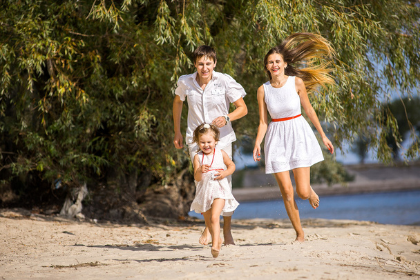 Anya, apa és lánya, séta a tengerparton - Fotó, kép