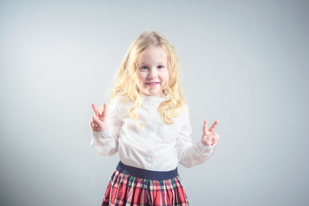Beautiful smiling blond girl in a school uniform - Фото, зображення