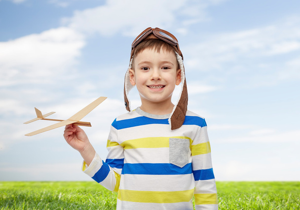 happy little boy in aviator hat with airplane - Фото, изображение