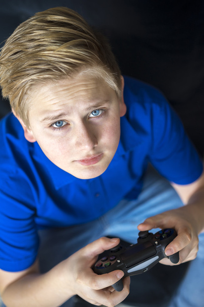 Serious video game playing teen looking up - Photo, Image