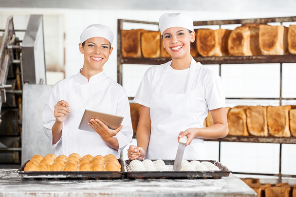 Smiling Female Colleagues With Digital Tablet In Bakery - Foto, Imagen