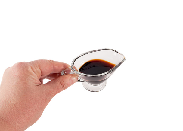 Soy sauce in glass saucers in hand isolated on white background. - Fotografie, Obrázek