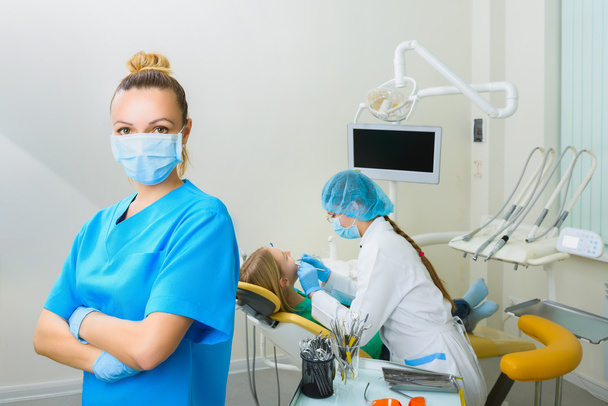 Dentist in surgical mask standing with arms folded at the dental clinic - Photo, Image