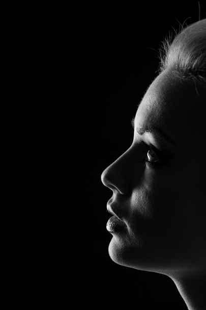 Woman portrait silhuette in darkness with soft light on face. - Photo, Image