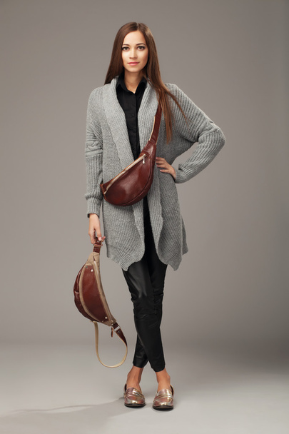 Elegant model in gray woven cardigan with two leather fanny pack - Фото, изображение