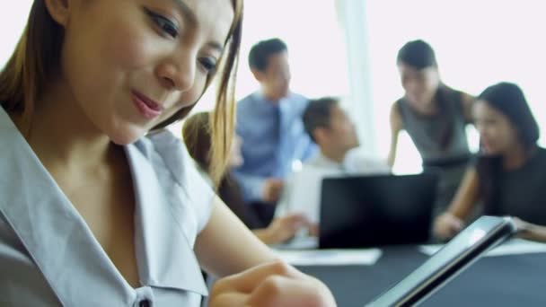 Азіатська бізнеследі за допомогою бездротового планшета - Кадри, відео