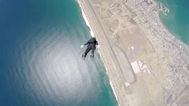 Skydiver está voando em queda livre acelerada acima da cidade costeira
 - Filmagem, Vídeo