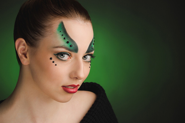 Kreatywnych makijaż młoda kobieta w odcieniach zieleni. - Zdjęcie, obraz