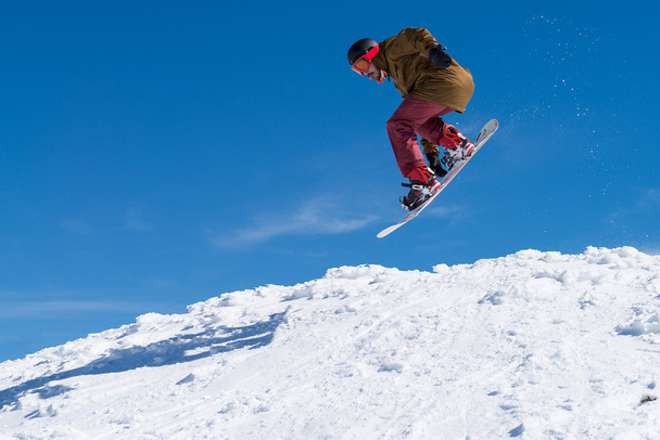 Snowboarder jumping against blue sky - Foto, Bild