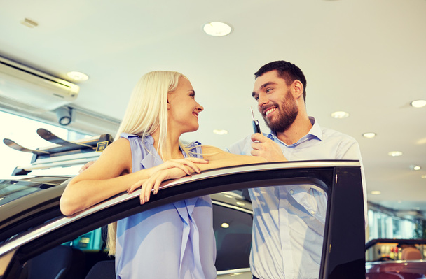 happy couple buying car in auto show or salon - Zdjęcie, obraz