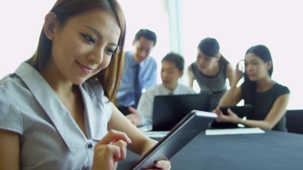 Mujer de negocios asiática utilizando la tableta inalámbrica
 - Metraje, vídeo