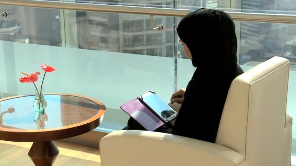 liikenainen, joka käyttää tablettia Dubain toimistorakennuksessa
  - Materiaali, video