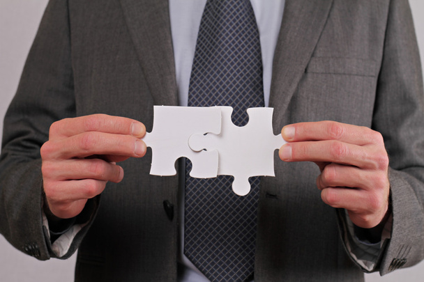 Business Man want to break up partnership, Business communication problems. Man holding two d pieces of puzzle which don't fit together - Photo, Image