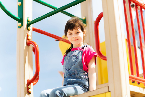 happy little girl on children playground - Foto, afbeelding