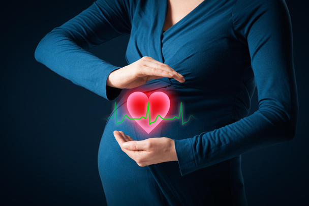 Mulher grávida com gesto protetor e coração
 - Foto, Imagem