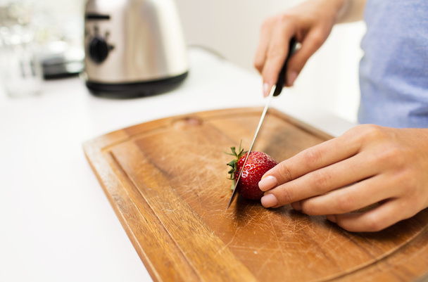 close up of woman chopping strawberry at home - Foto, Bild