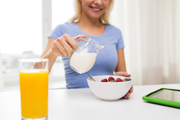 close up of woman with milk jug eating breakfast - Foto, Imagen