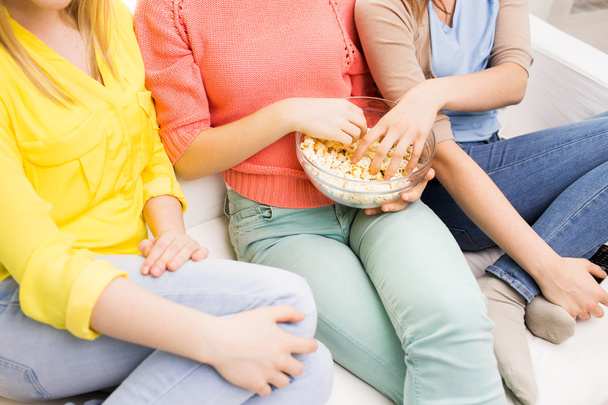 close up of teenage girls eating popcorn at home - Foto, afbeelding