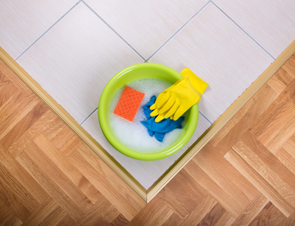 Lavatório com ferramentas de limpeza no chão
 - Foto, Imagem