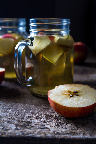 A refreshing jug of apple cider on wood table - Foto, afbeelding