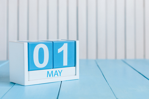 1 мая. Изображение 1 мая деревянный календарь цвета на белом фоне. Весенний день, пустое место для текста. Международный день работников
 - Фото, изображение