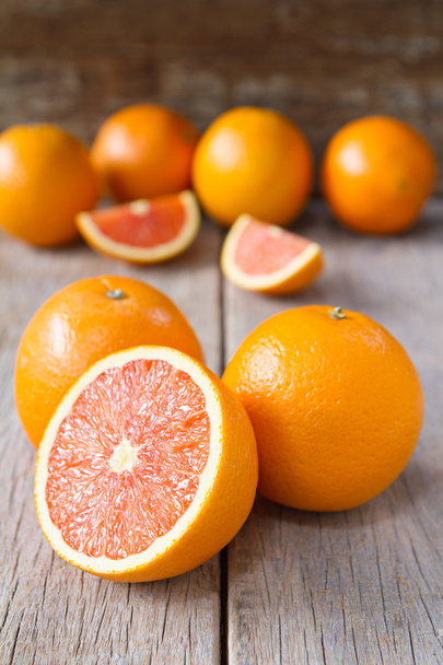Fresh oranges with slices on wooden background. - Photo, Image