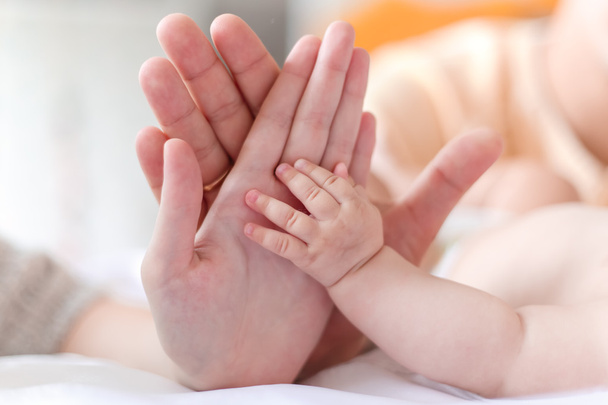 Ojciec i matka trzymać w ich ręce ręka trochę nowo narodzonego dziecka - Zdjęcie, obraz