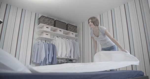 Молодая домохозяйка делает кровать необработанной
 - Кадры, видео
