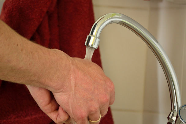 Henkilö pesee käsiään
 - Valokuva, kuva