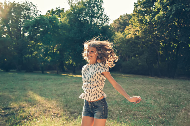 Tyttö hyppii puistossa
 - Valokuva, kuva