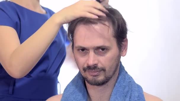 O cabeleireiro seca ao cabelo de homem o secador de cabelo
 - Filmagem, Vídeo