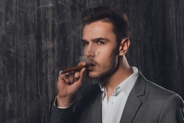 Close up portrait of pretty businessman smoking a sigar - Foto, Imagem