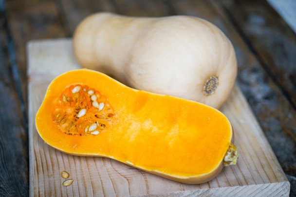 Uncooked sliced butternut squash on wooden background - Foto, afbeelding