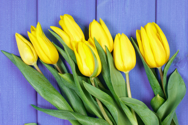 Bouquet of fresh tulips on purple wooden background - Fotó, kép