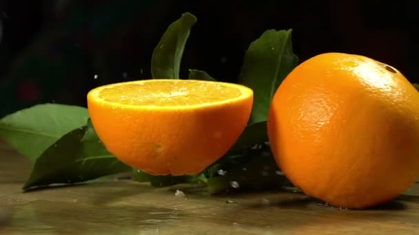 Groep van sinaasappelen met bladeren op houten planken. - Video