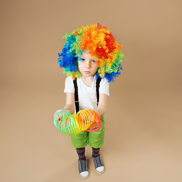 Garçon clown heureux avec grande perruque colorée
. - Photo, image
