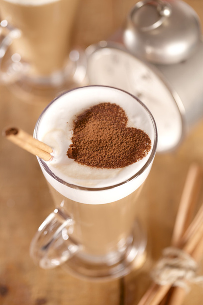 Coffee latte with cinnamon sticks and cacao heart , shallow dof - Photo, Image