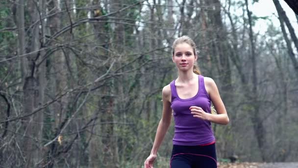 Läuferin joggt auf Waldweg in Park. - Filmmaterial, Video