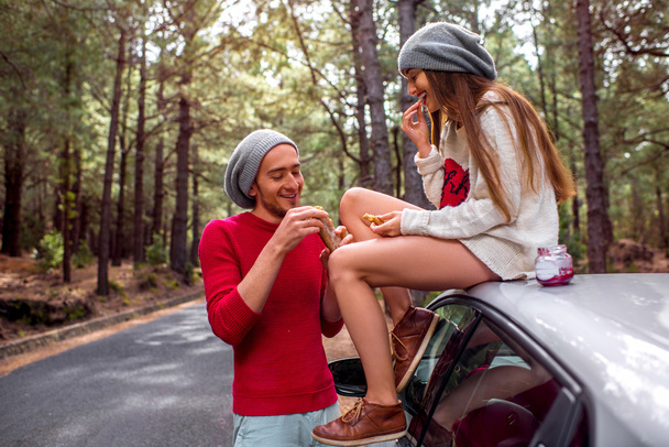 Young couple traveling by car in the forest - Fotoğraf, Görsel