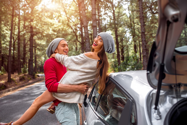 Young couple traveling by car in the forest - Foto, imagen