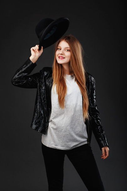 Portrait of beautiful young girl wearing black felt hat and leat - Fotografie, Obrázek